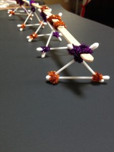 A bridge made of q-tips, pipe cleaner, and toothpicks.