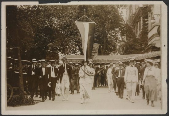 Bastille Day protest with Julia Hurlbut leading the first group of marchers. Iris Calderhead of Kansas at right waiting for mobs to attack pickets so she can order out new banners, July 14,1917. Library of Congress photograph.